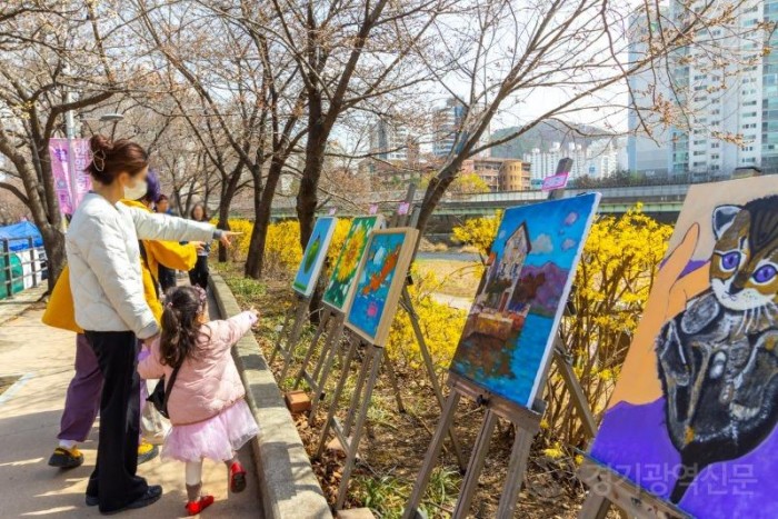 사진4) 시민들이 30일 2024 안양충훈벚꽃축제 산책길에서 소울음아트센터 전시 작품을 자연과 함께 즐기고 있다.JPG